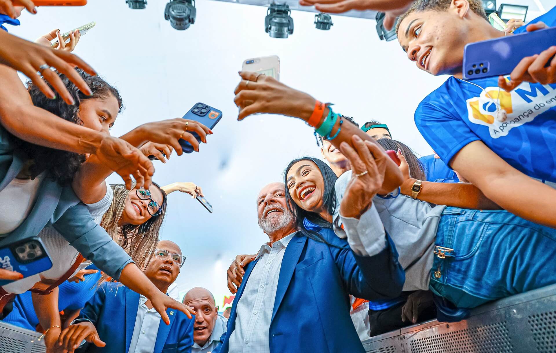 Lula cercado por estudantes que fazem selfies durante um evento do programa
